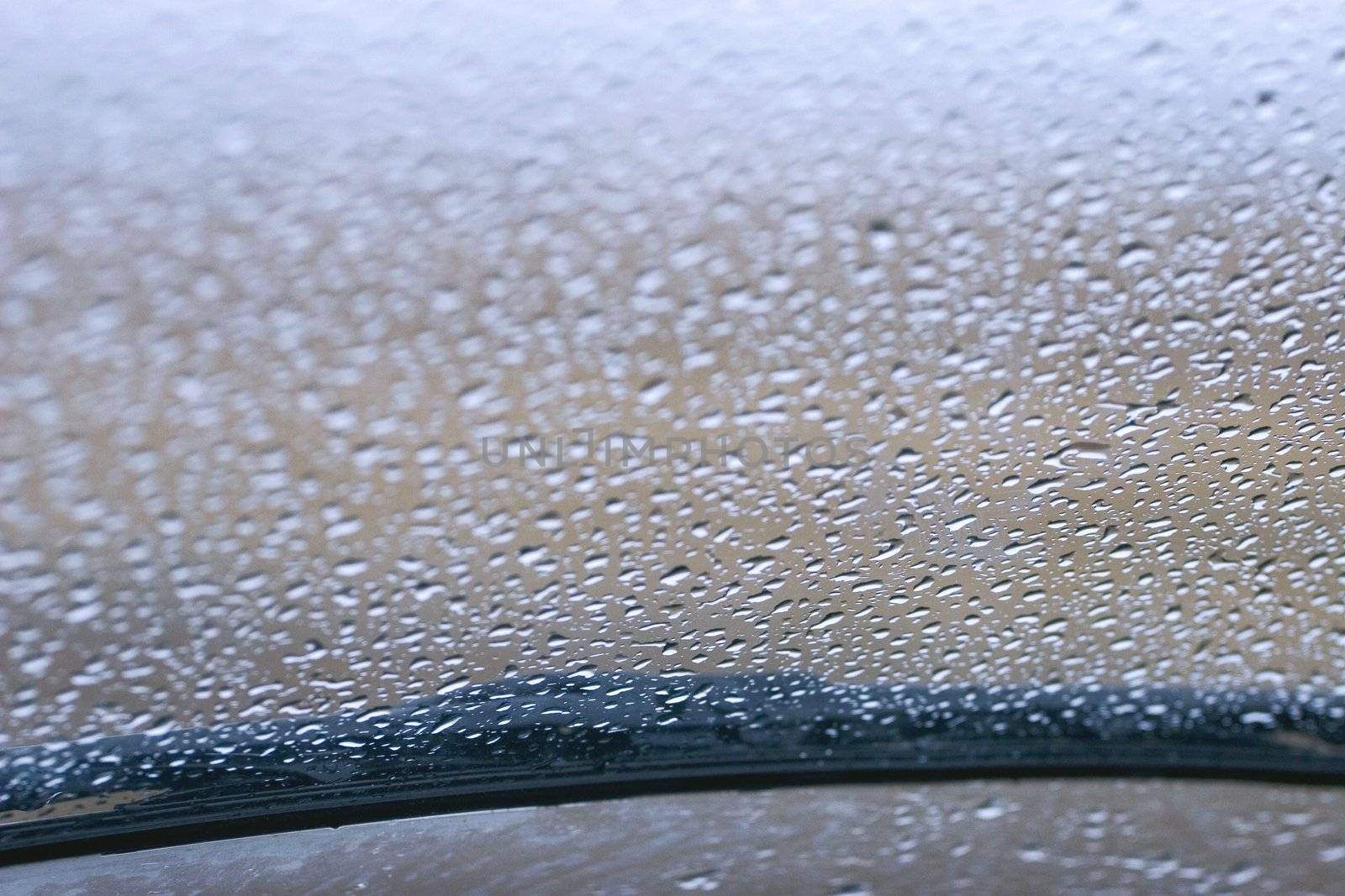 View of rain on a windshield with a wiper blade from the inside