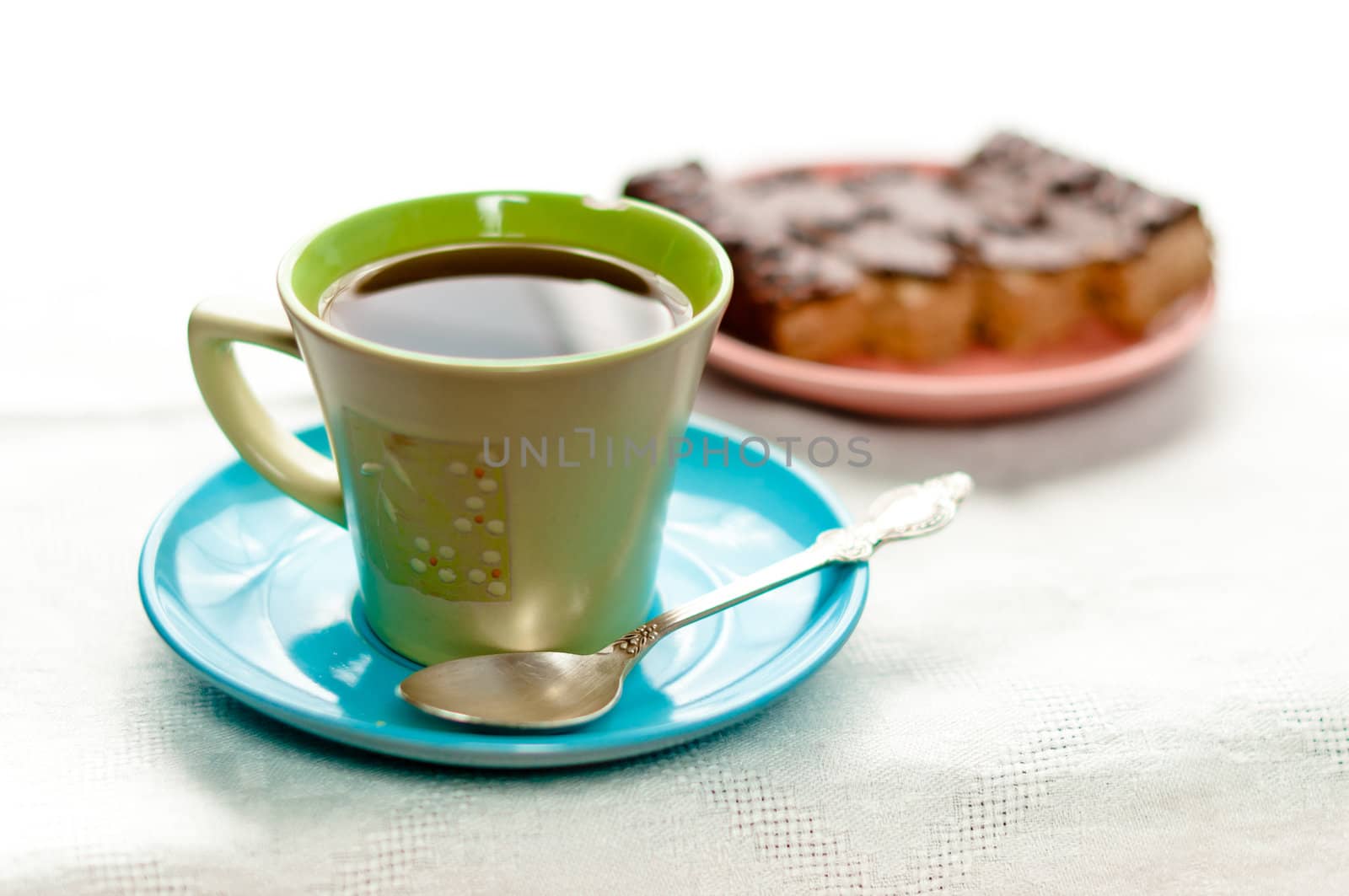 A cup of tea standing on table with small pie part on background