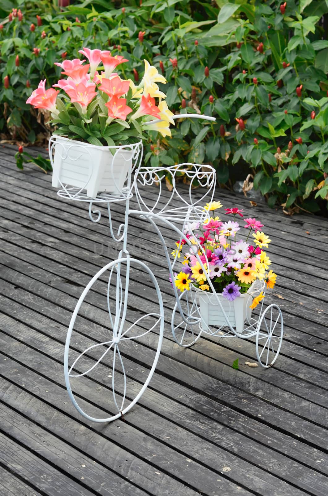 White steel bike and flower pots in the garden