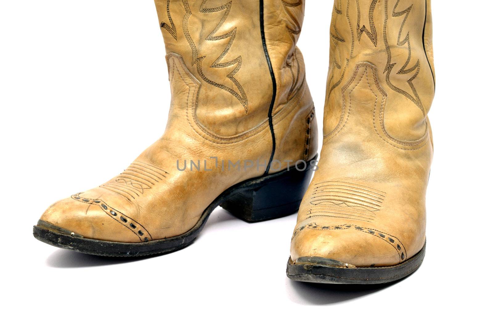 An old pair of leather cowboy boots isolated on white