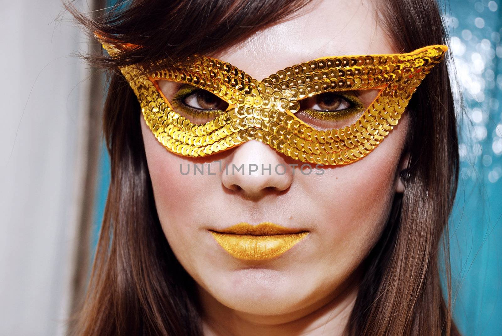 Close-up portrait of a beautiful brunette in a masquerade mask.