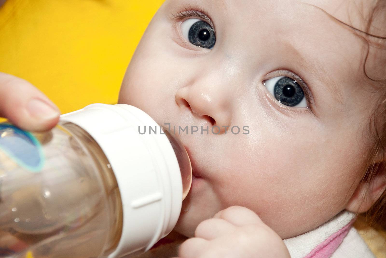 Little boy drinking juice from a bottle. Close-up.
