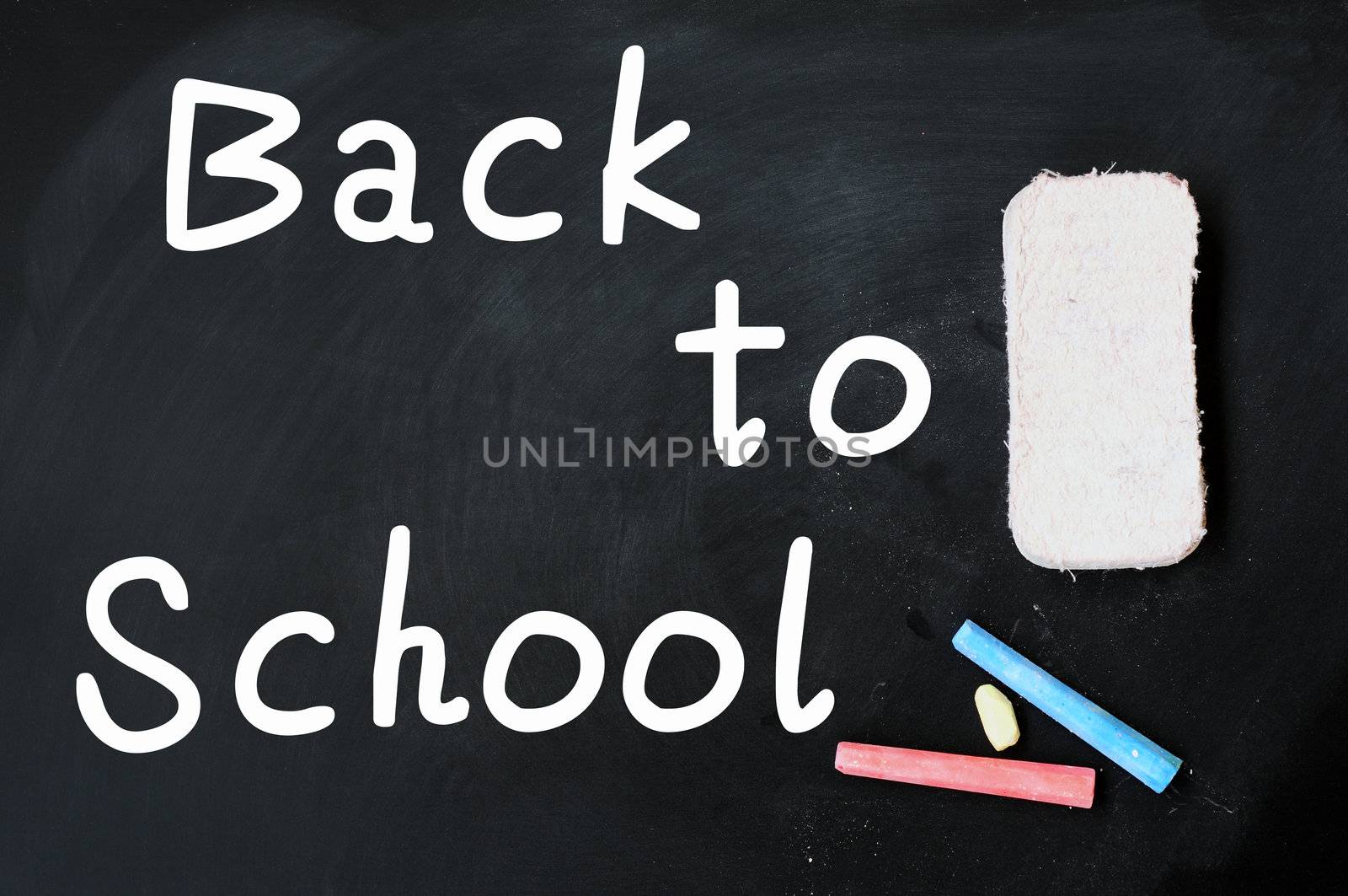 Back to School written on a chalkboard, with eraser and chalk