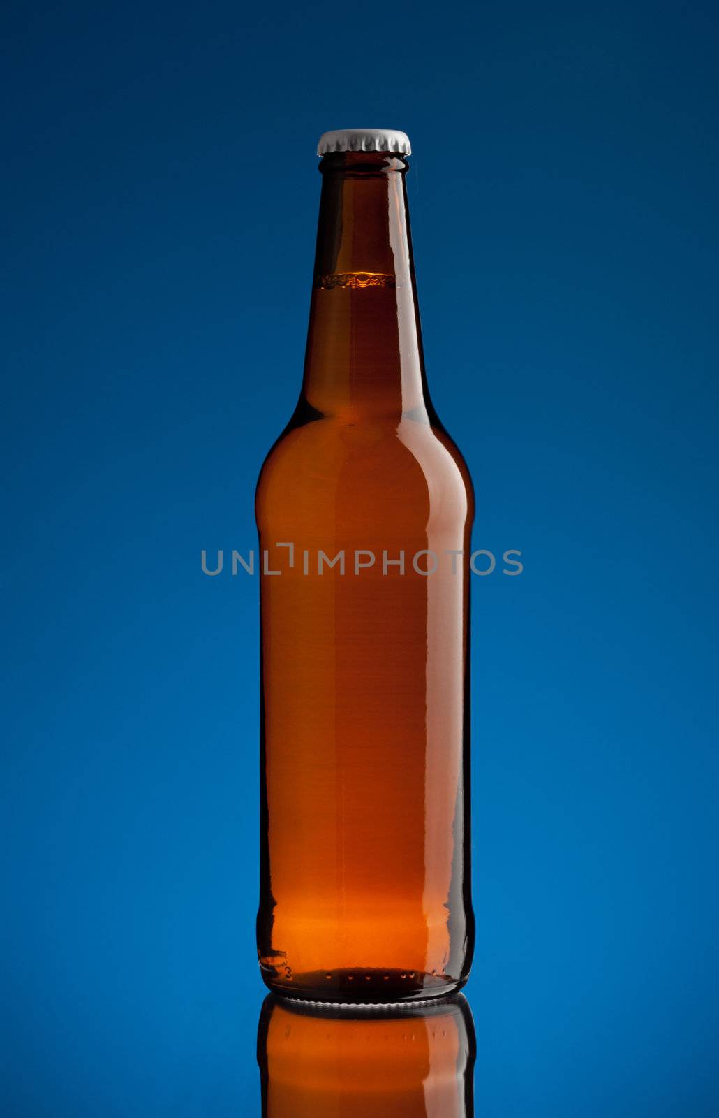 brown bottle with beer over blue background