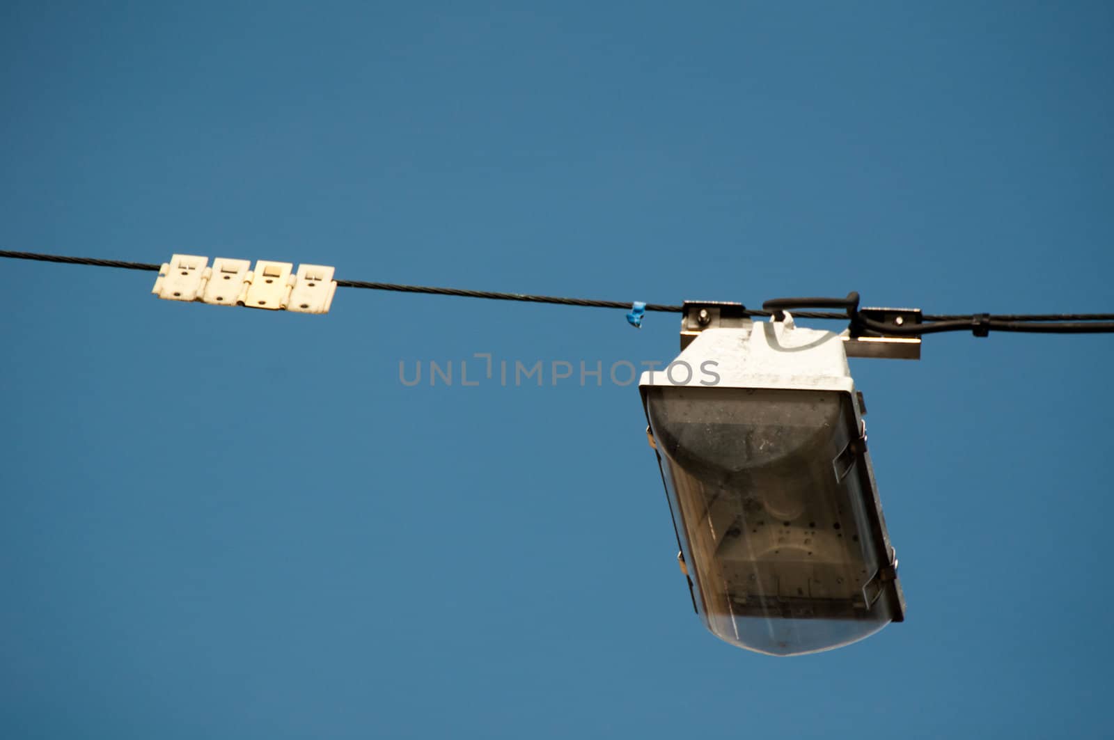 street light hanging above a street with great blue sky