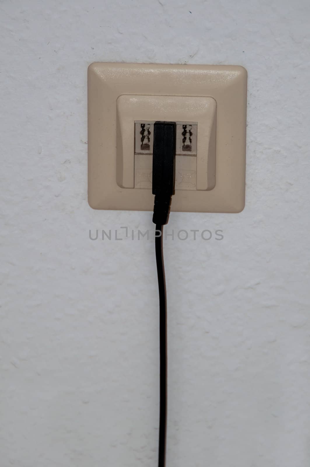 Old fashioned German phone box and cable mounted to papered wall