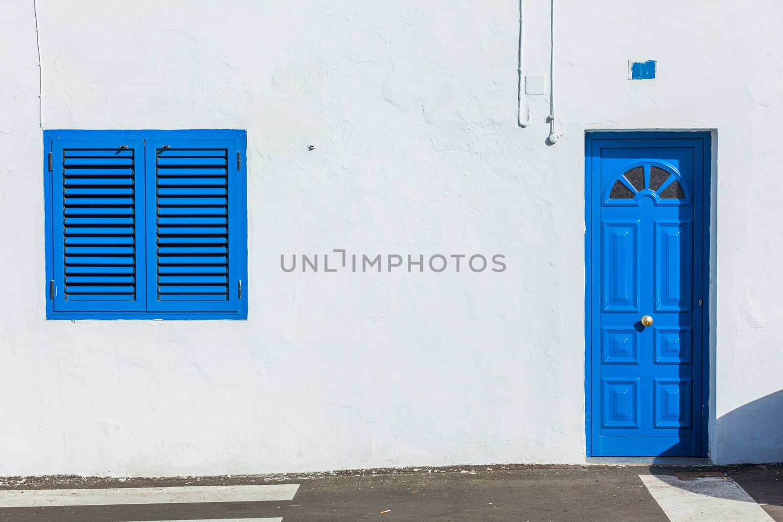 Blue colonial window and door on a wall made out of wood