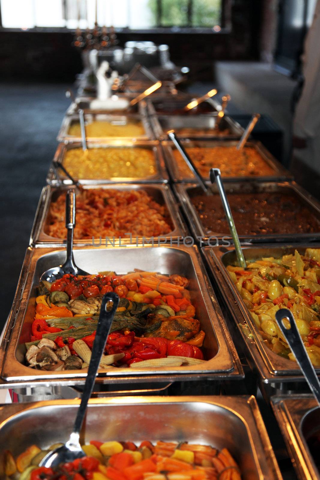 Long row of hot vegetables in stainless steel containers on a catered buffet at a wedding reception or function
