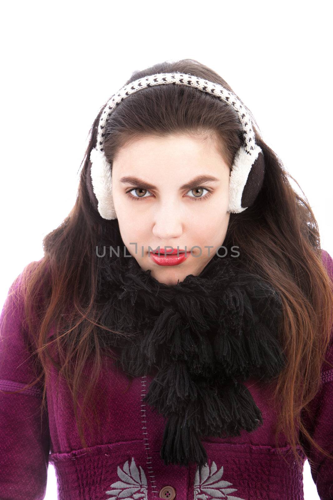 Cold woman wearing ear muffs and a thick winter scarf snuggling down into her clothing on a winter day isolated on white