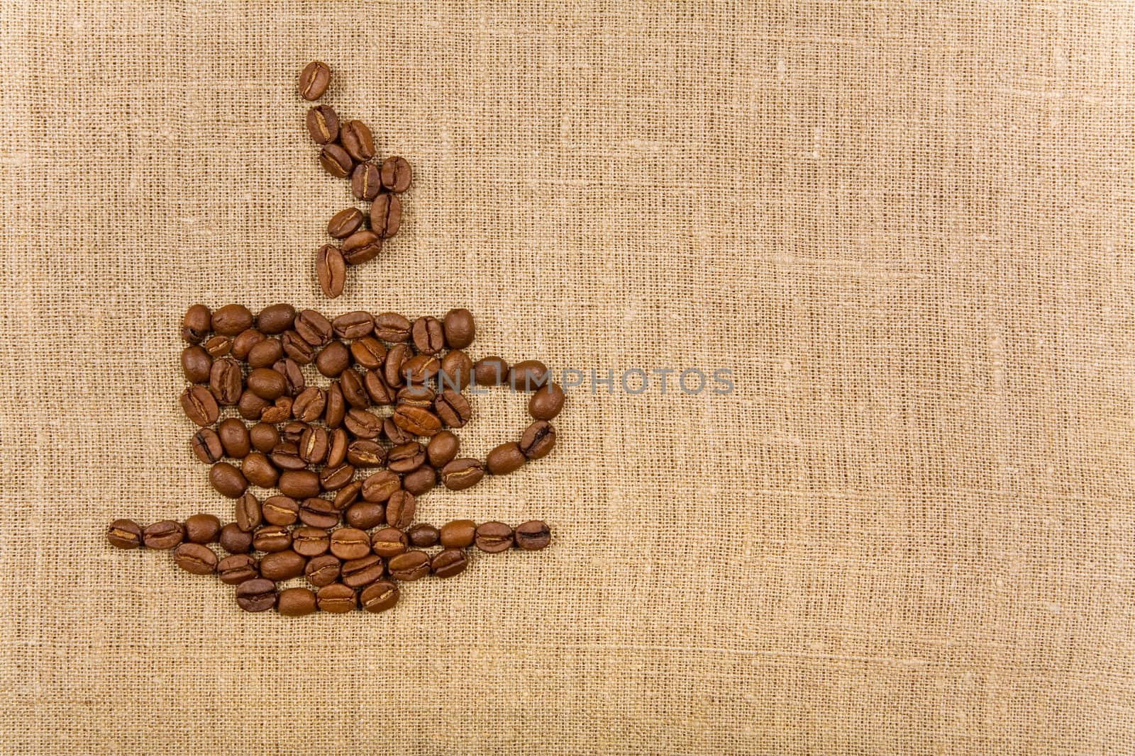 Coffee cup made of beans over canvas background, lot of copy-space 