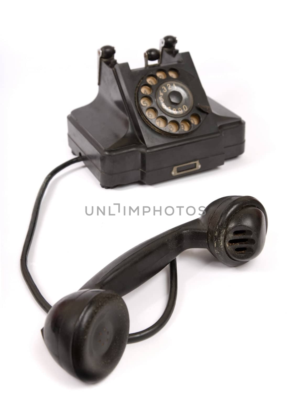 Black vintage phone with scratches with receiver off the hook, selective focus 