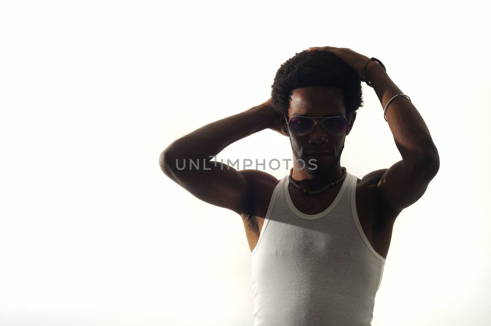 Low key portrait of young african american man with hands on the head, isolated on white