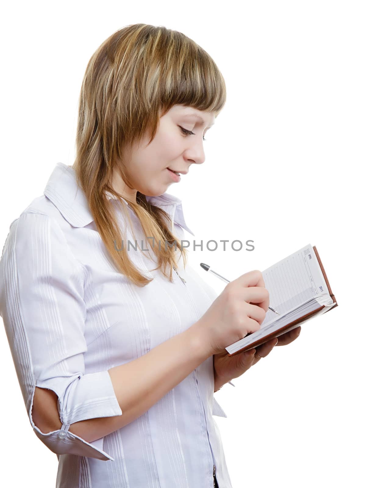 young girl in a white blouse writes in a notebook