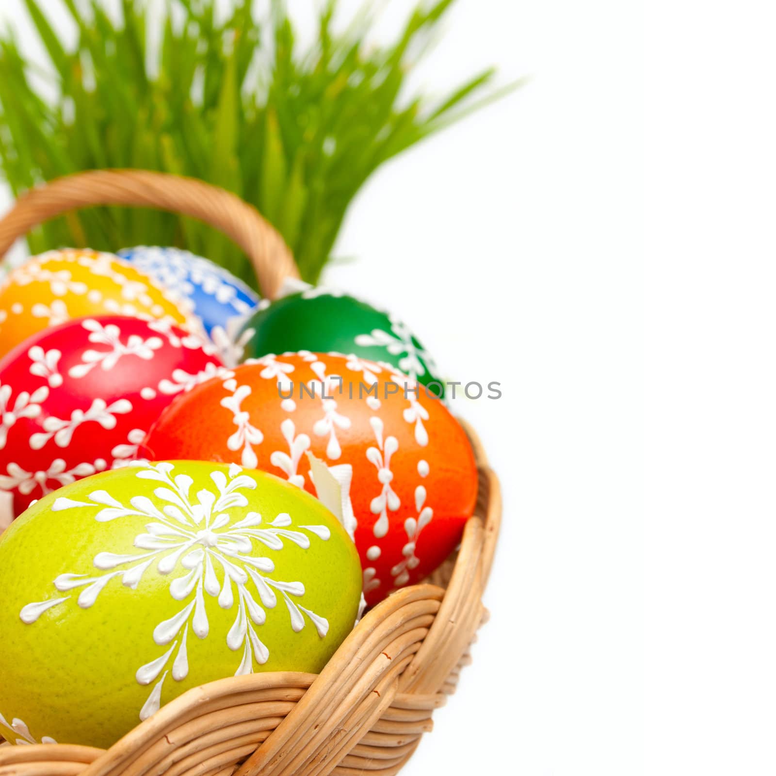 Easter Hand Painted Eggs in Basket and Grass Isolated on White