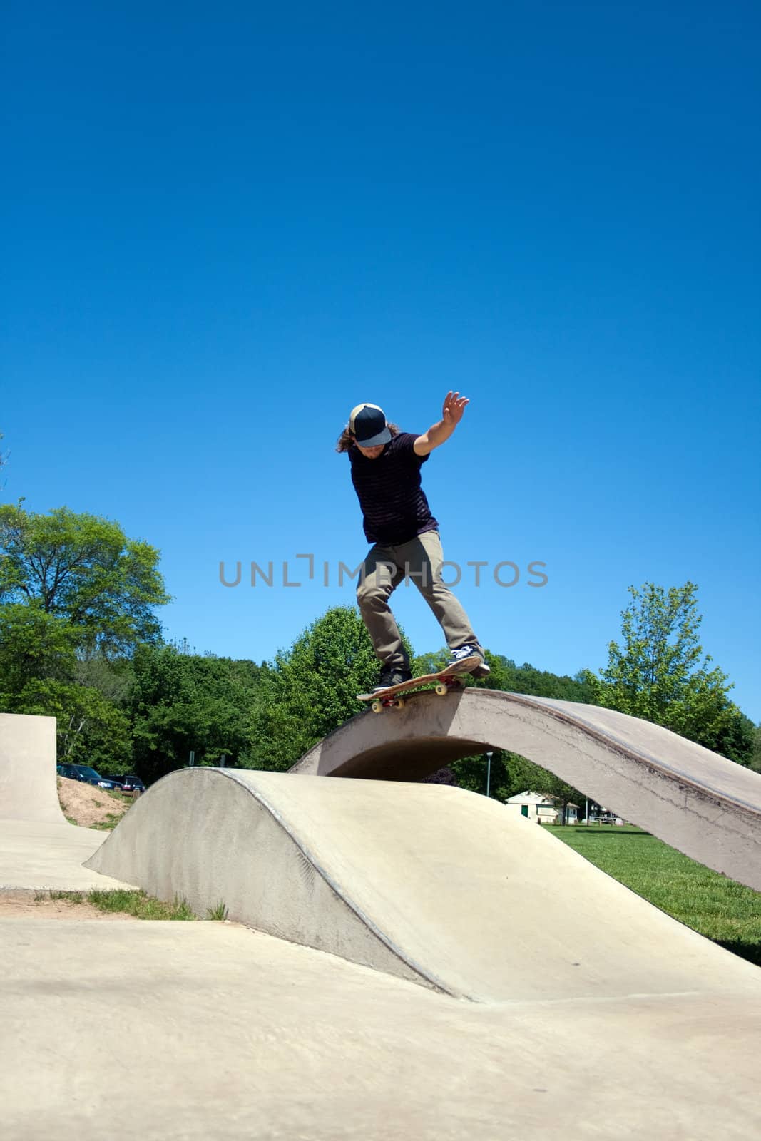 Action shot of a skateboarder performing a grind at a concrete skate park.