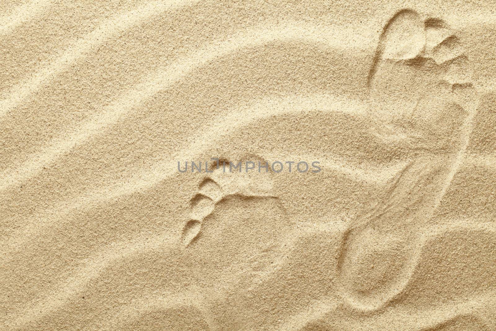 Footprints in the sand waves as background 