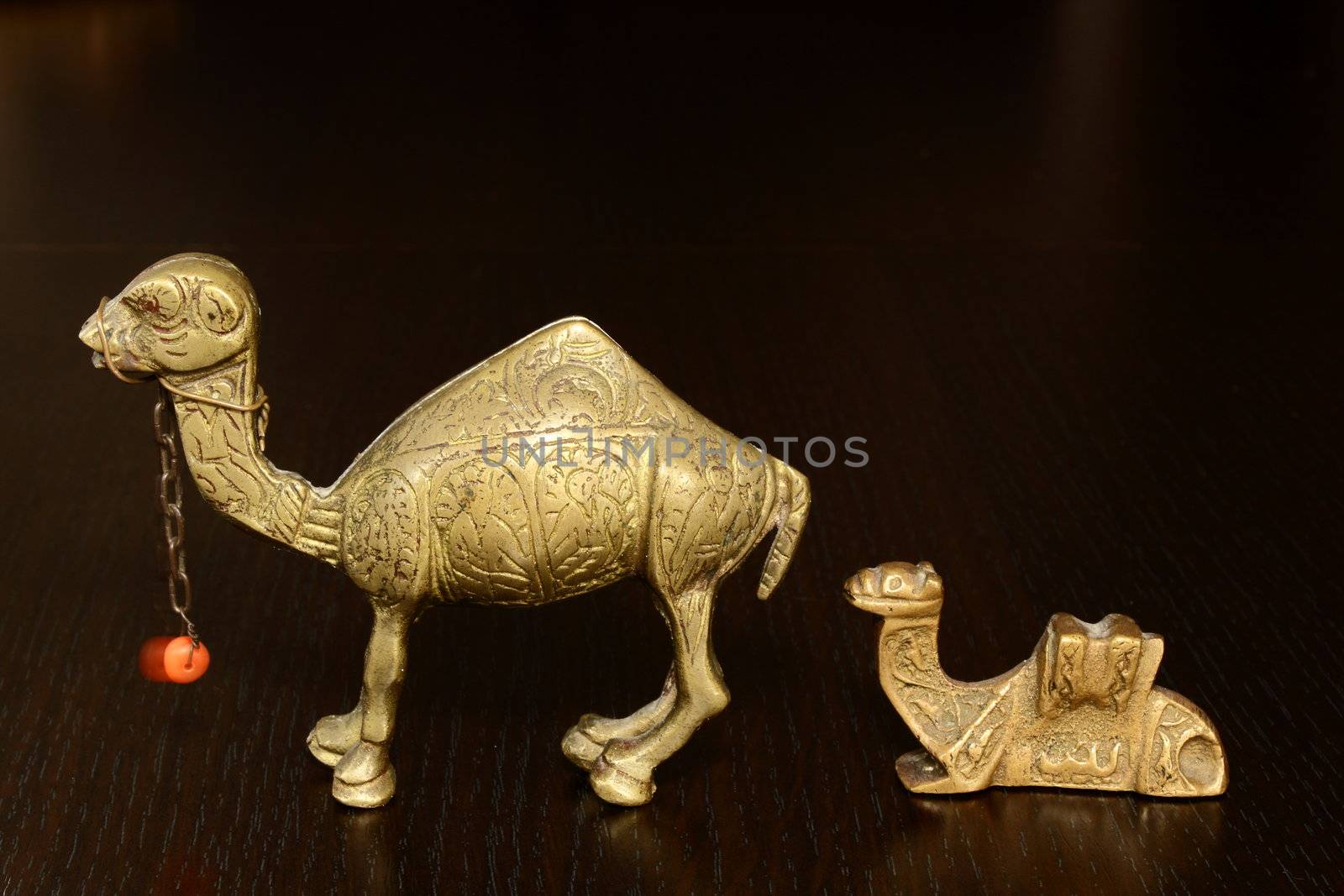 vintage bronze camel with balancing orange bead at its neck