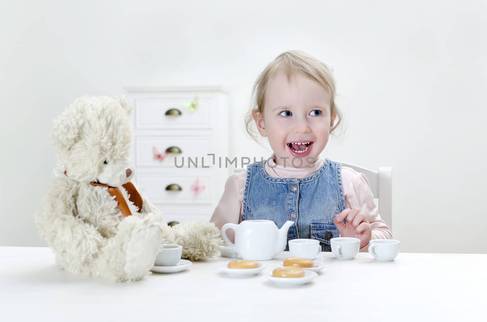 Child drink tea with bagels at home.