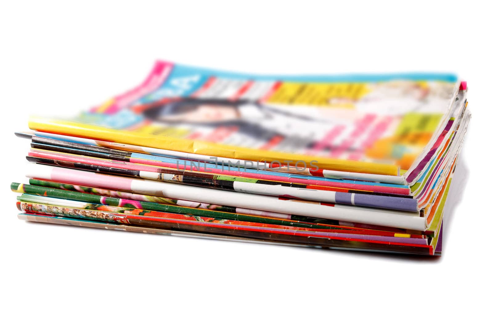a stack of old colored magazines on white