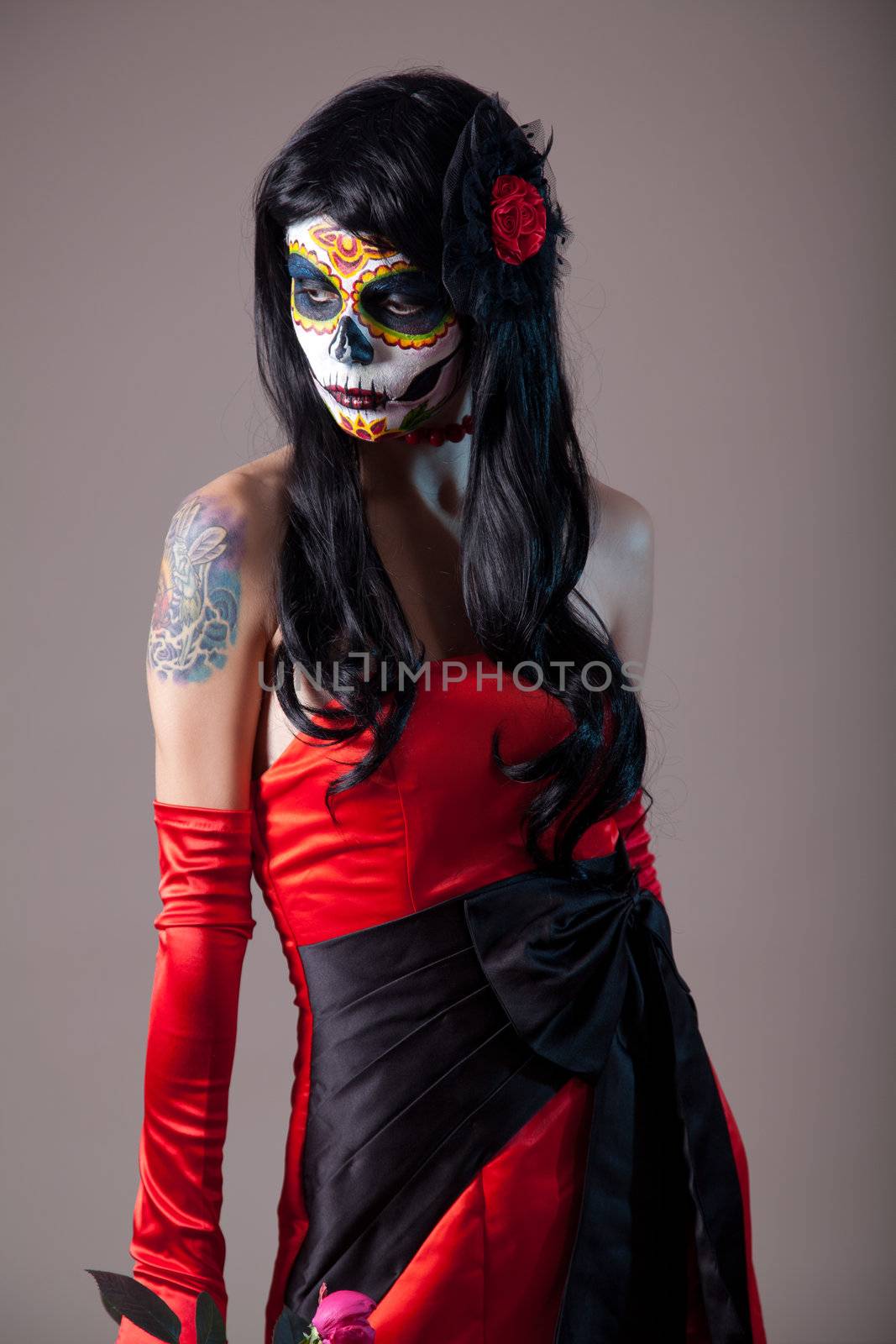 Sugar skull girl in red evening dress, studio shot 