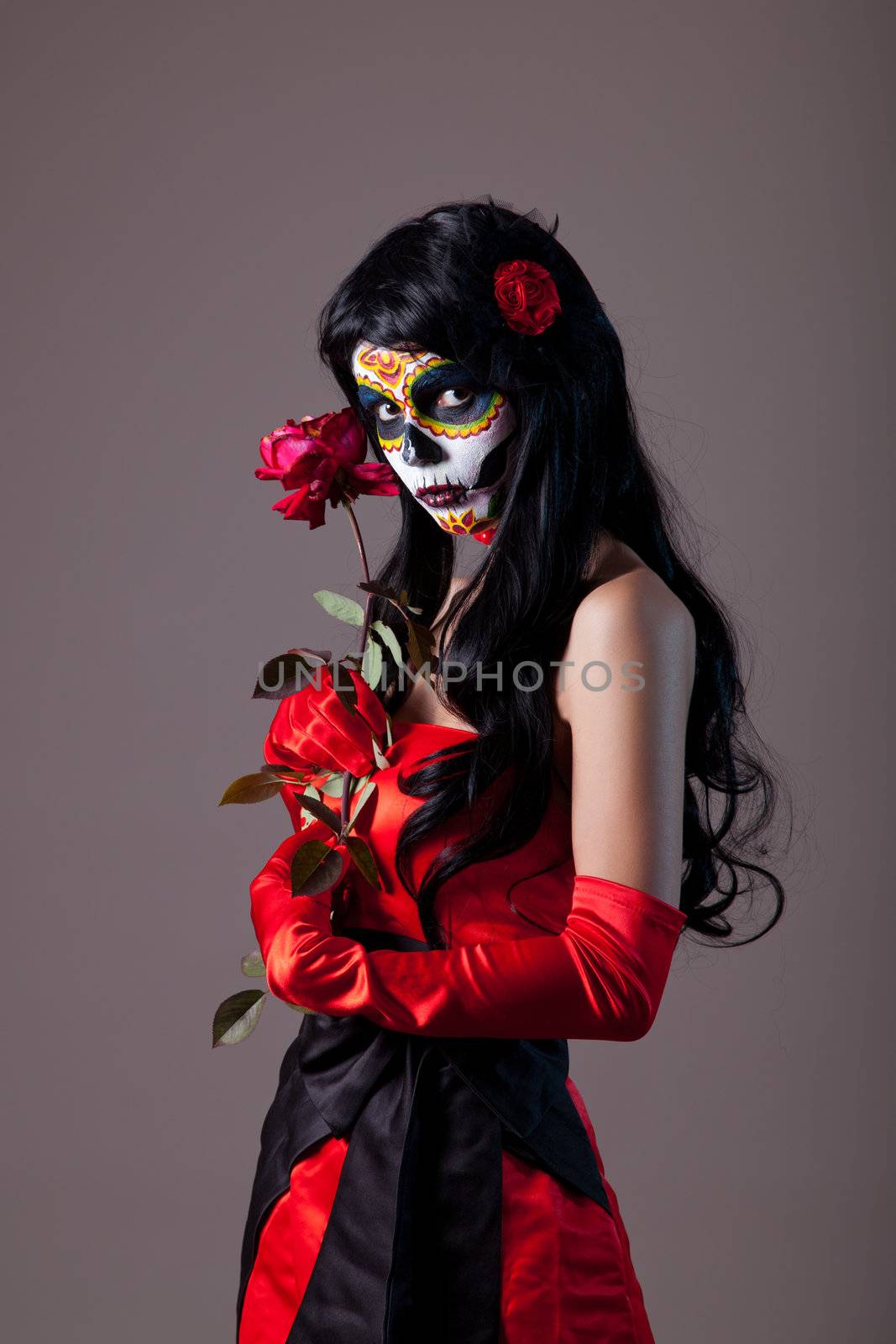 Sugar skull girl with red rose, studio shot 