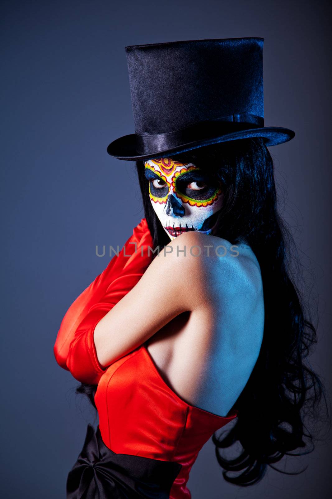 Sugar skull girl in tophat and red dress, studio shot 