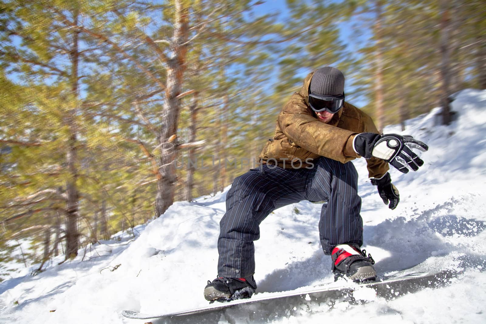 Snowboarder rides at high speed through the winter forest. Close-up. Motion Blur.