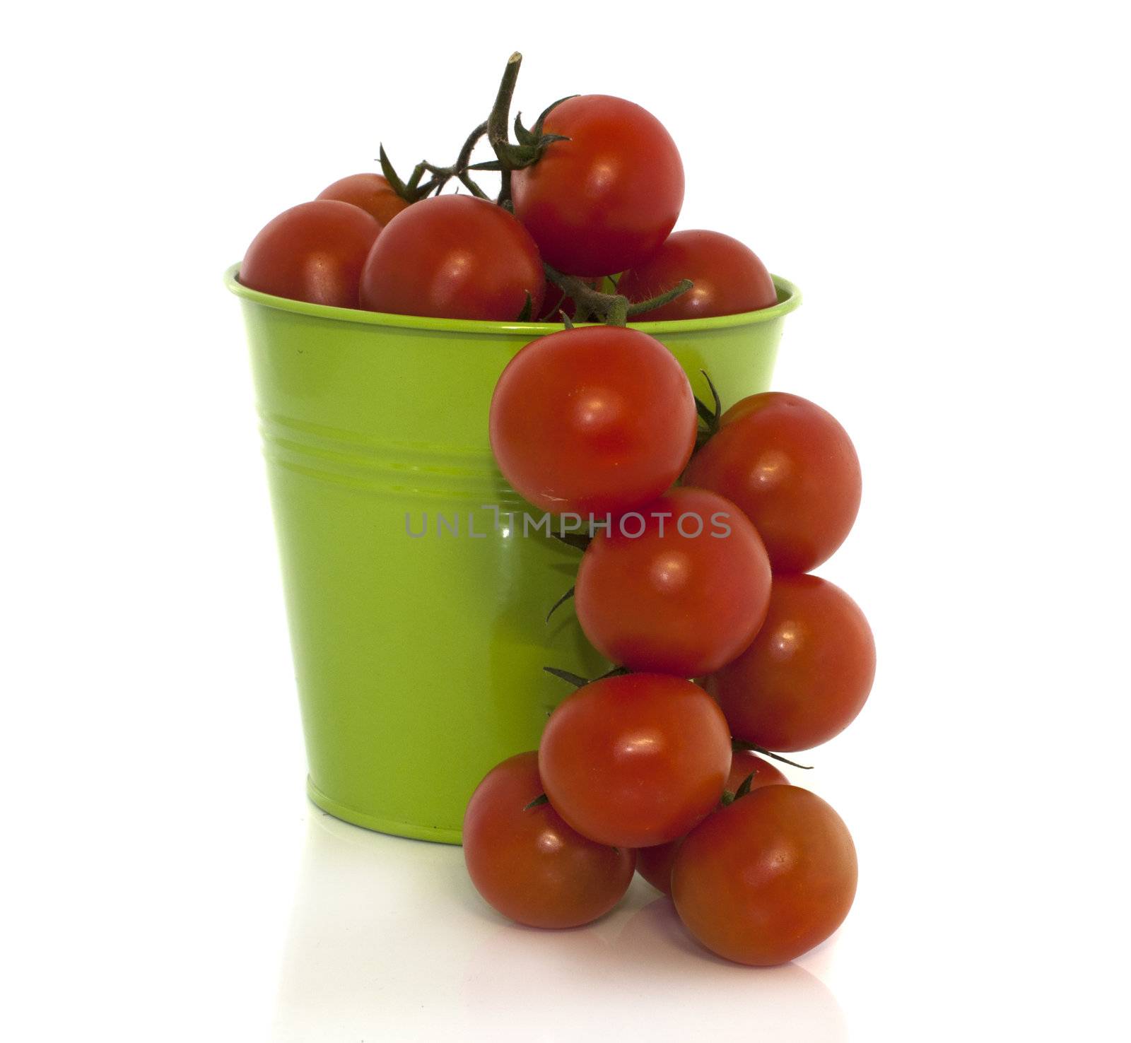 green basket with red tomato isolated on white