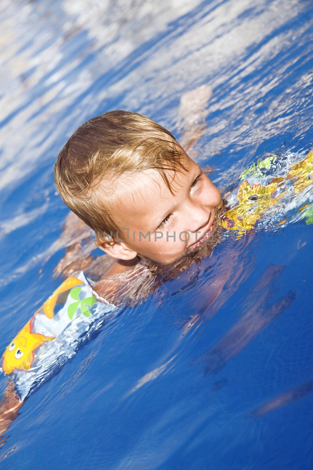 Little boy in pool water by Serp