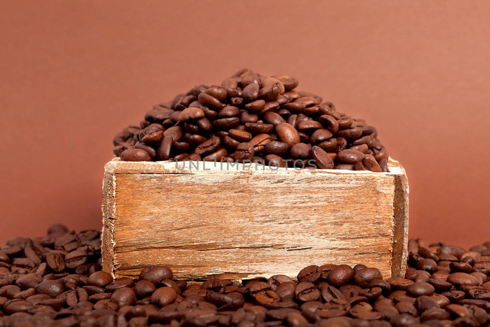 coffee beans in the old box, on brown background