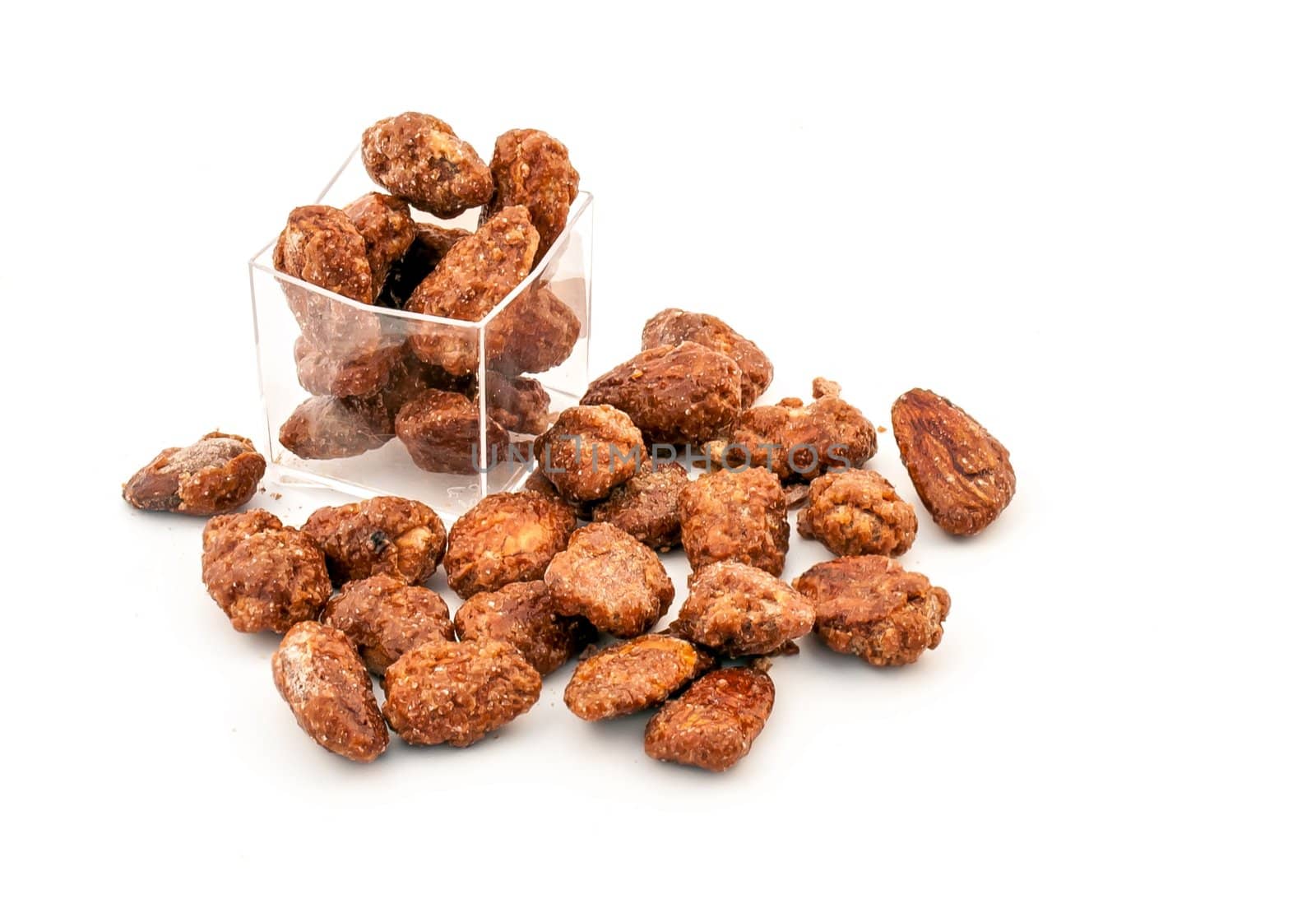 Scattered caramelized almonds finger food on white background