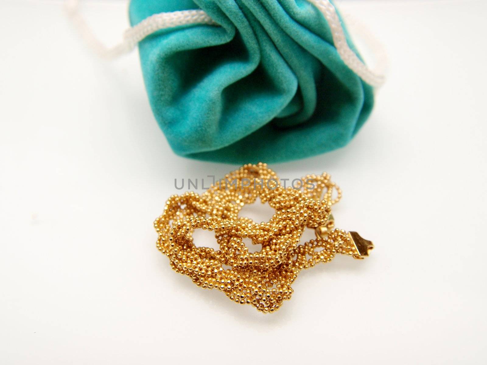 Yellow gold and jewelry bag, isolated towards white