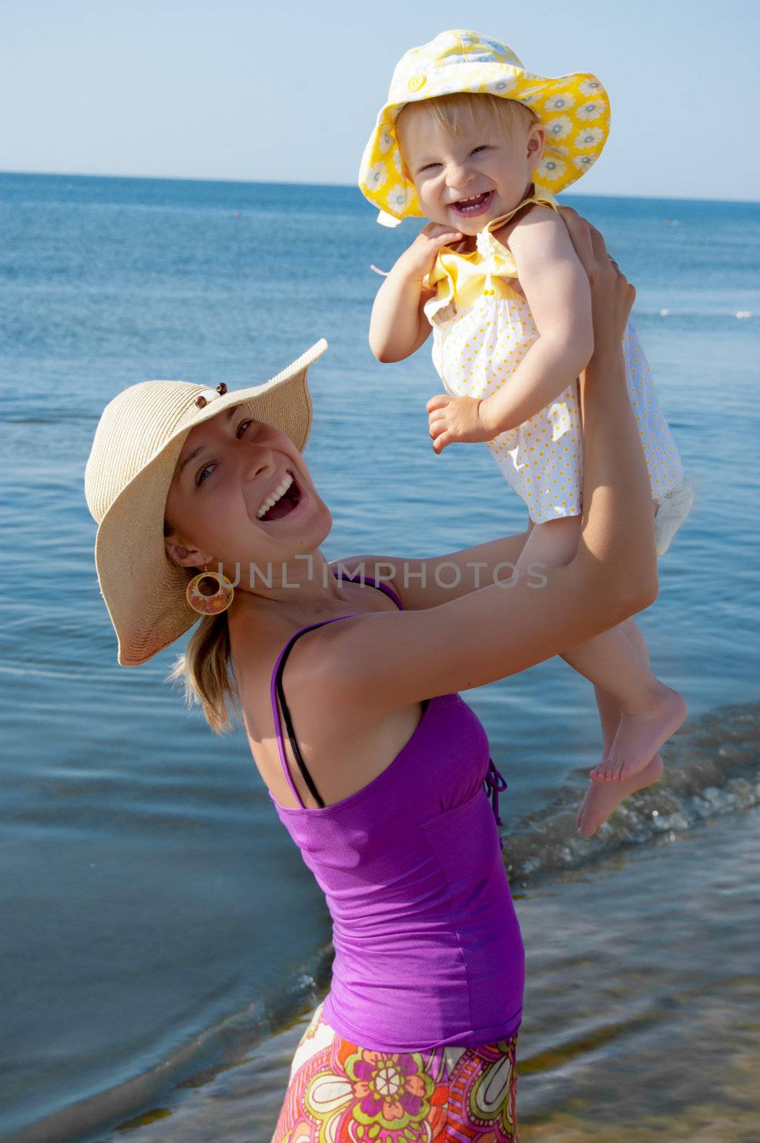 Joyful mother and daughter at beach in summer