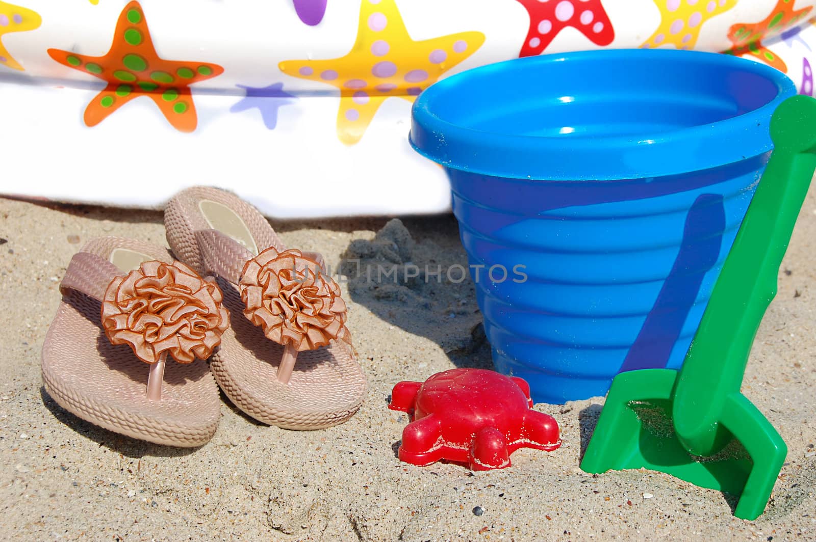 Children beach toys, bucket, spade and shovel on sand on a sunny day