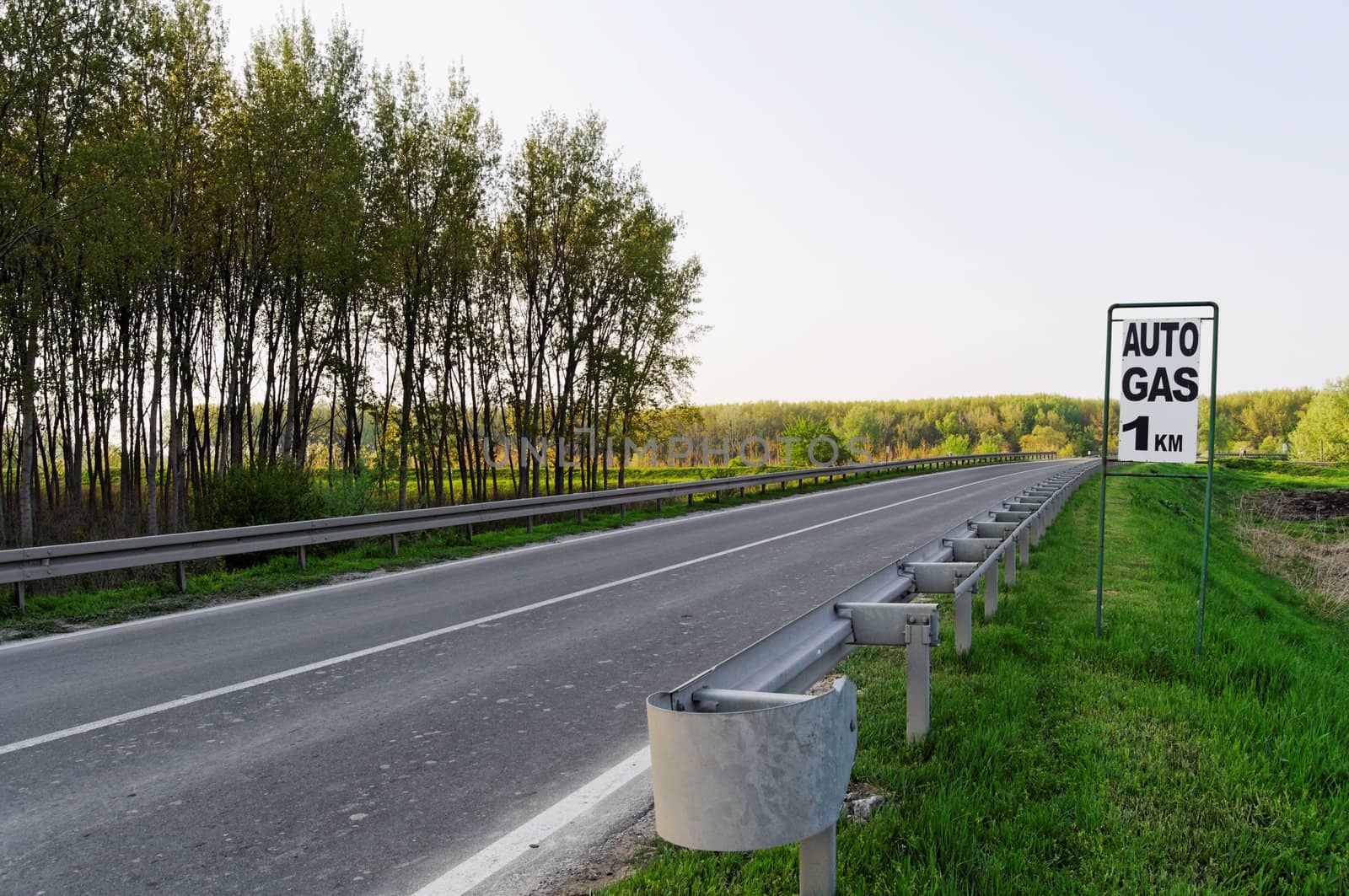 European asphalt road with auto gas sign ahead, horizontal shot