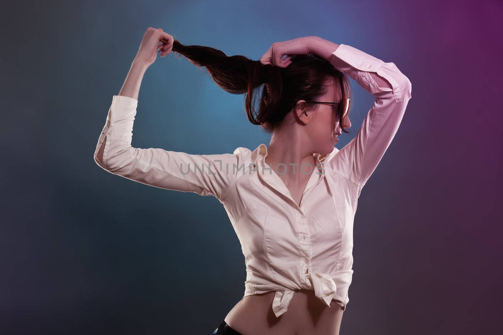 young woman in colorful disco light pulling her hair 