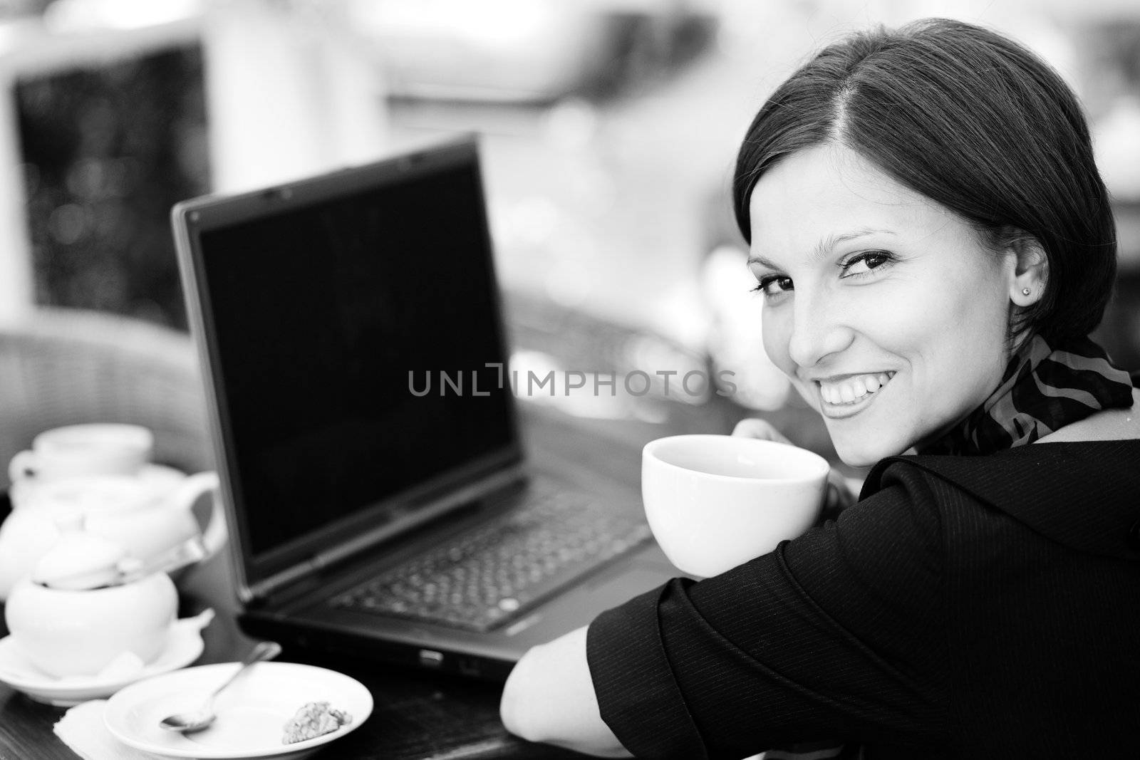 An image of a young woman at the table with laptop
