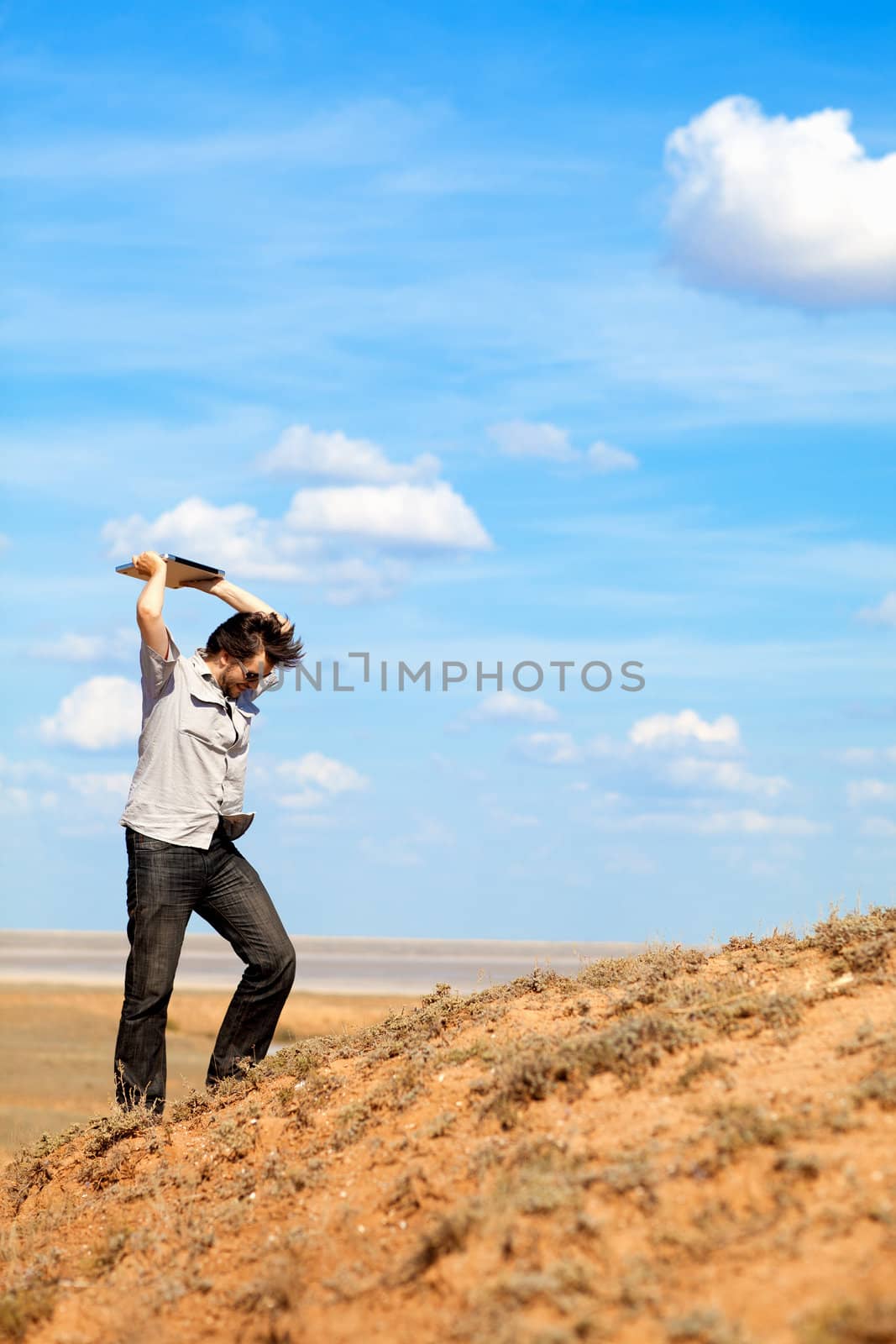 angry man throwing laptop outdoors