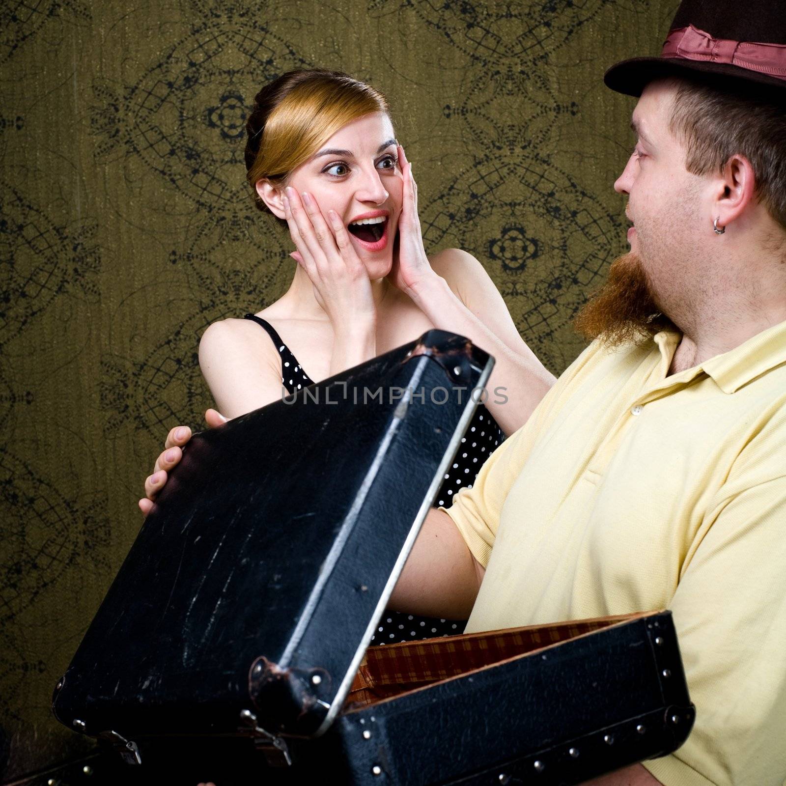 An image of a woman and a man with a valise