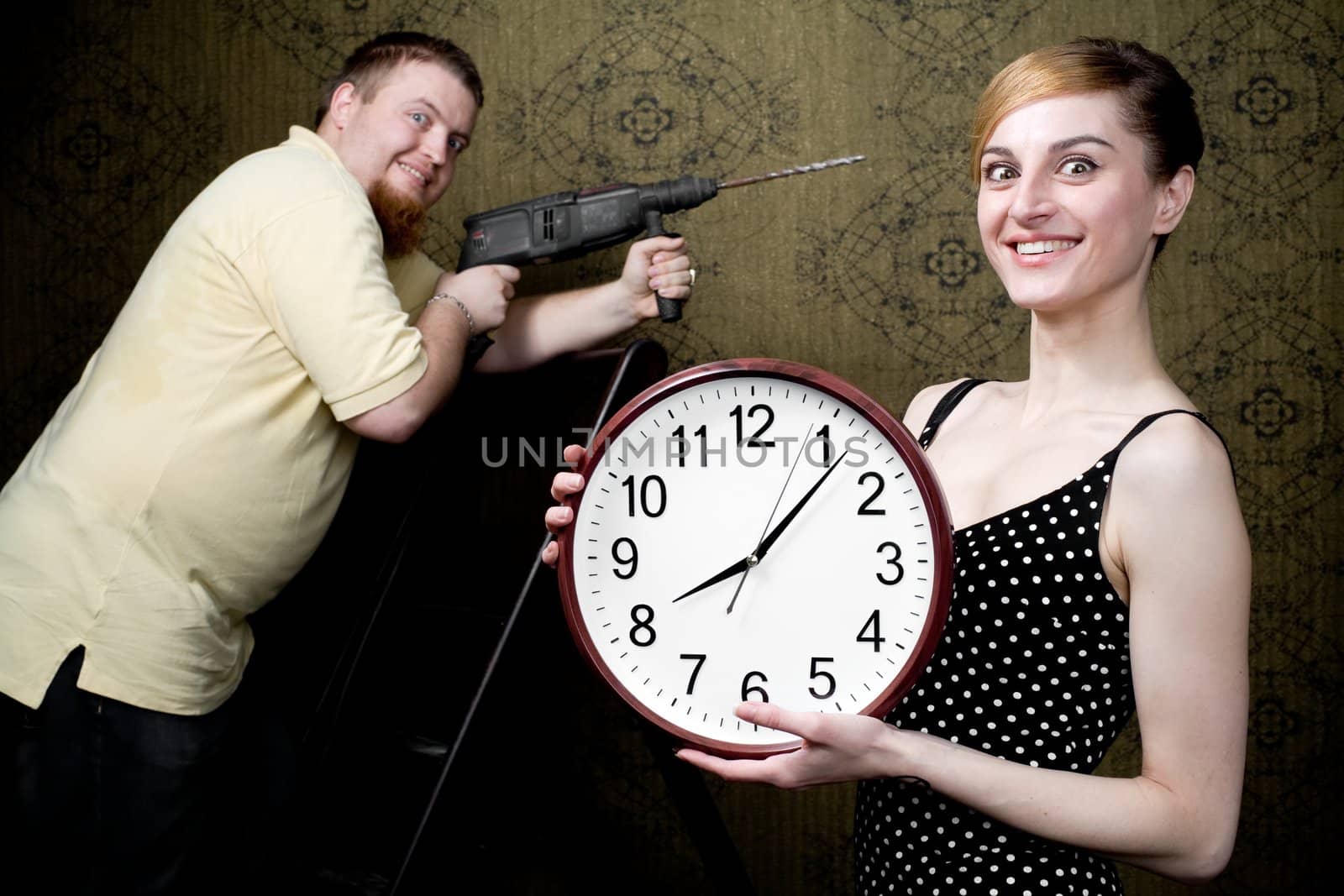 An image of a woman with new clock and a man with drill