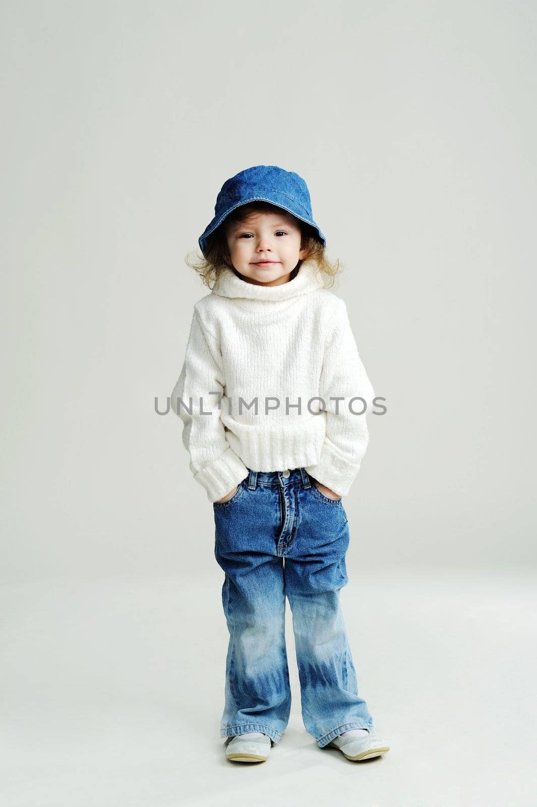 An image of a little girl in a blue hat and white jumper