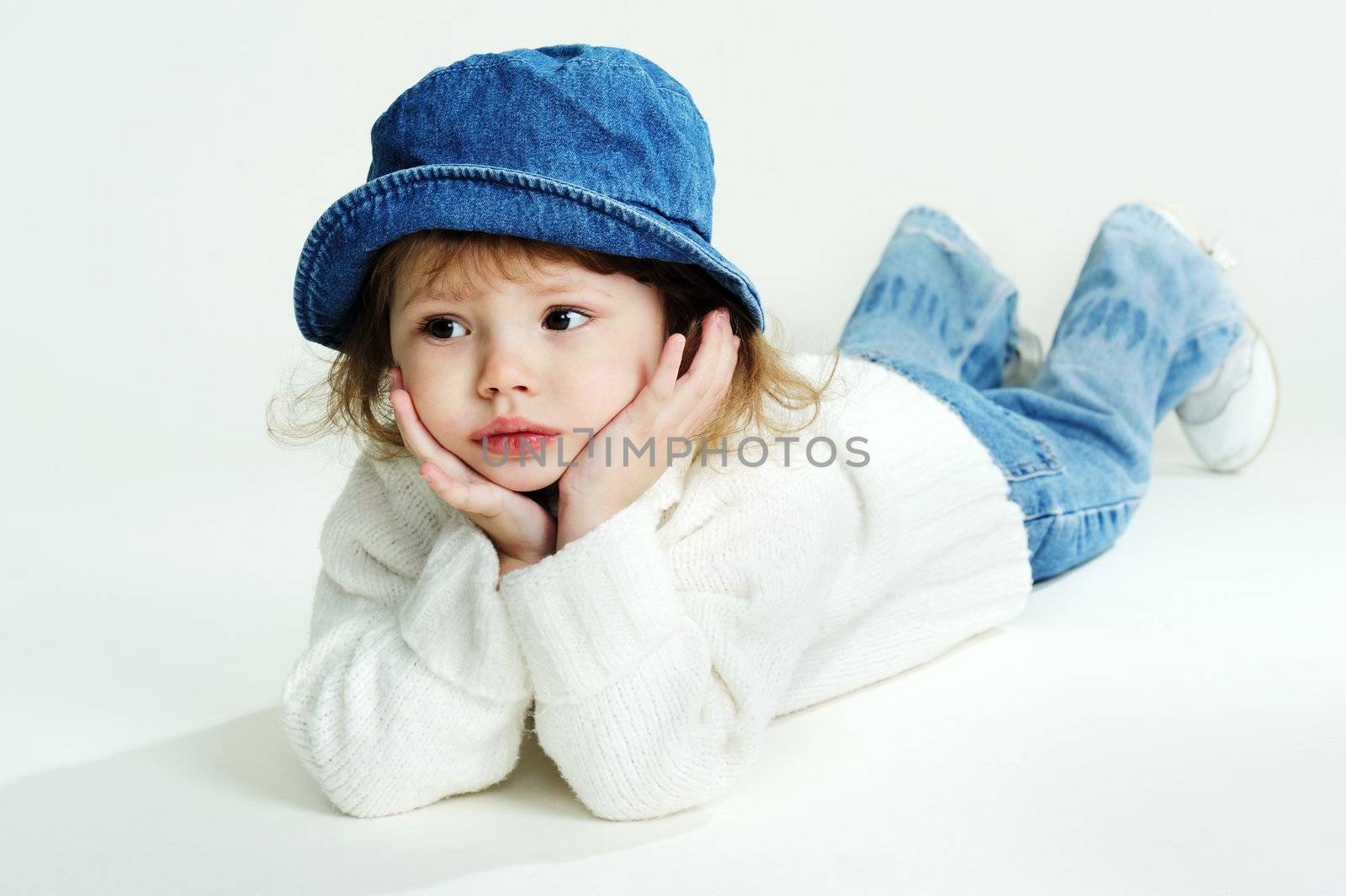 An image of a little girl in a hat and white jumper