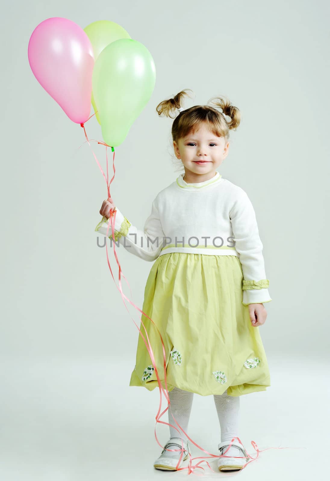 A portrait of a nice little girl with three balloons