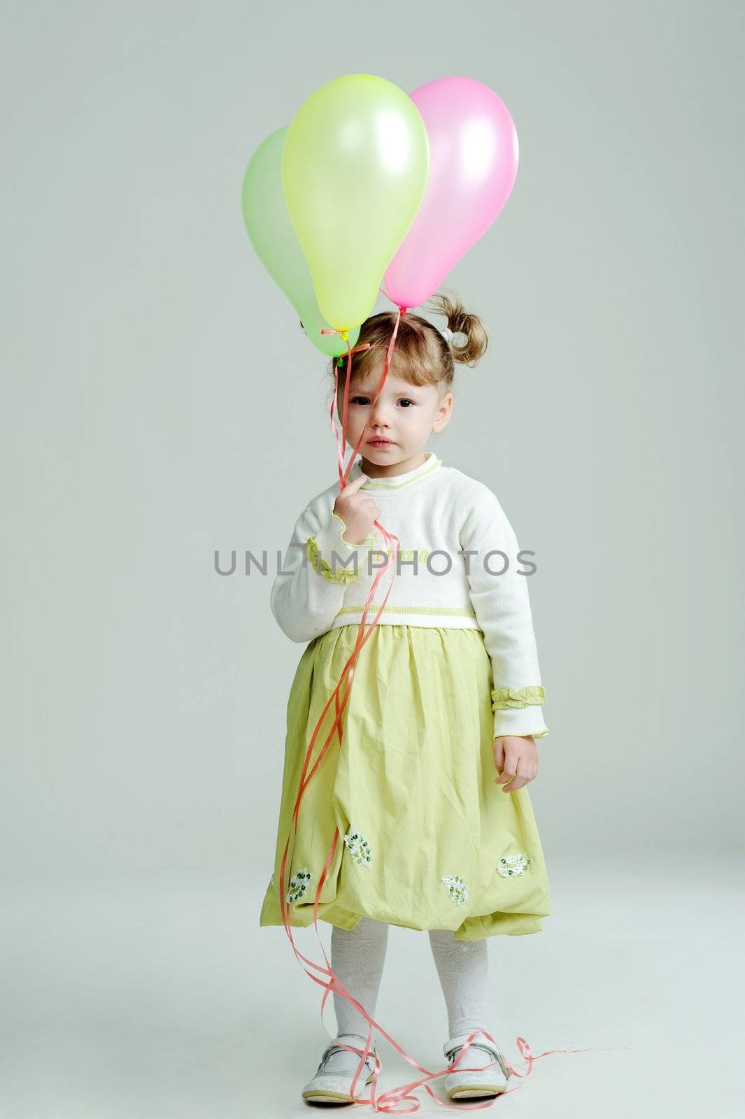 A portrait of a little girl with three balloons