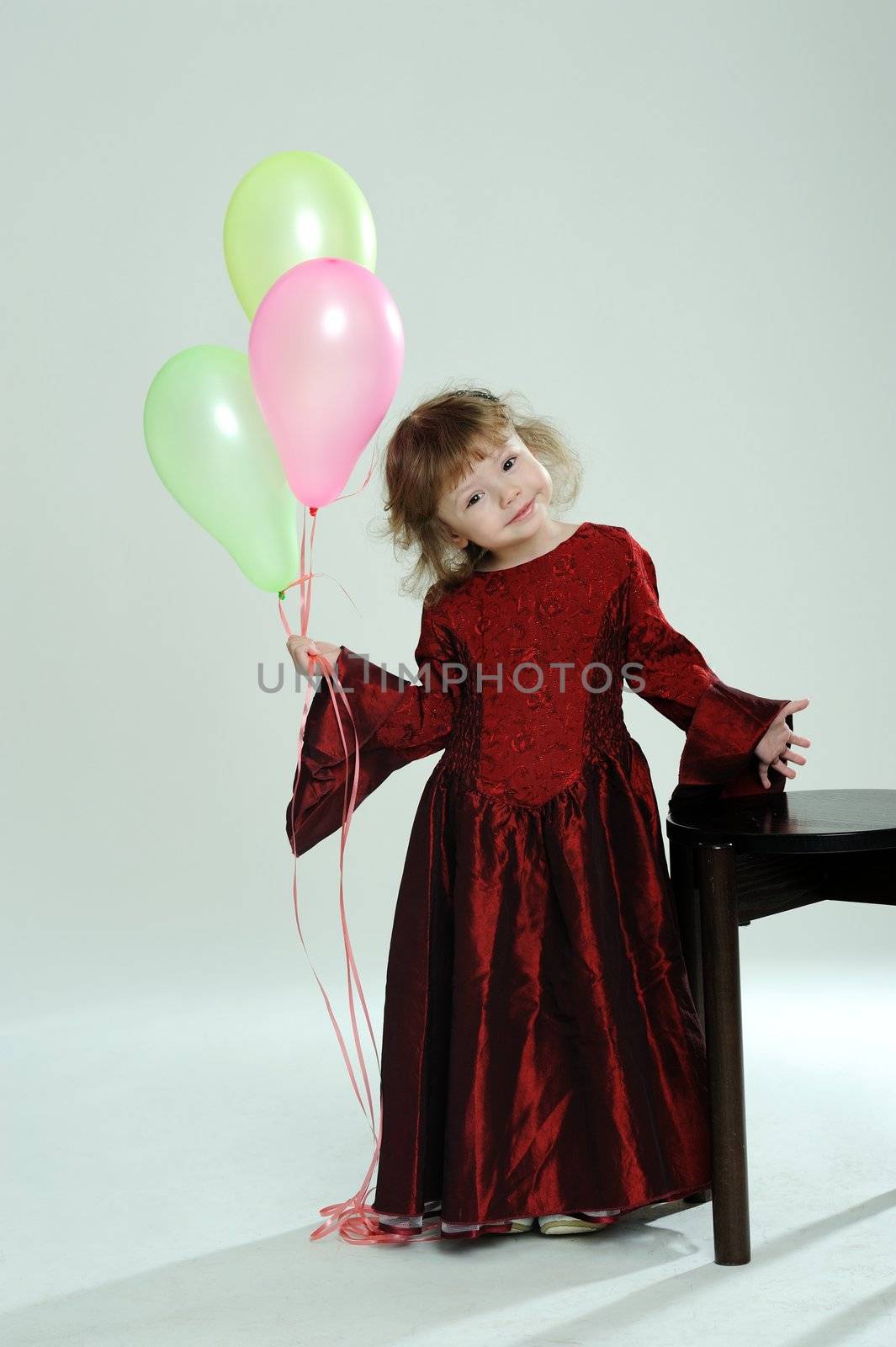 An image of a little girl in red dress with balloons
