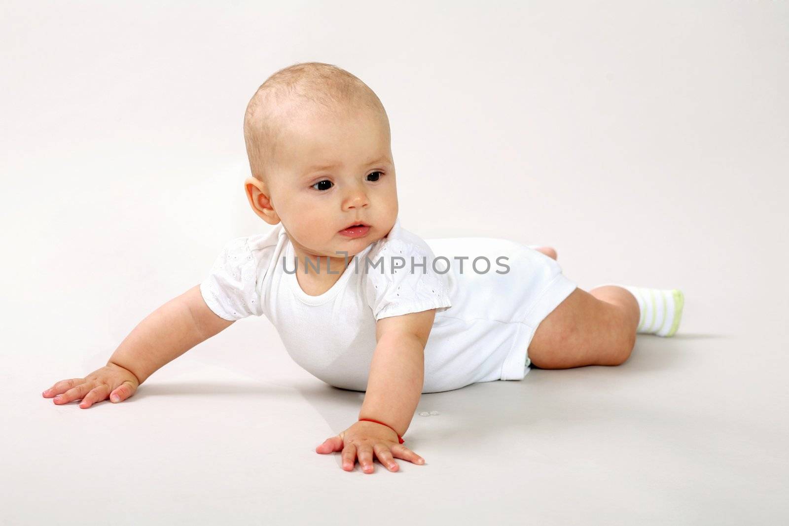 An image of a little baby-girl crawning in studio