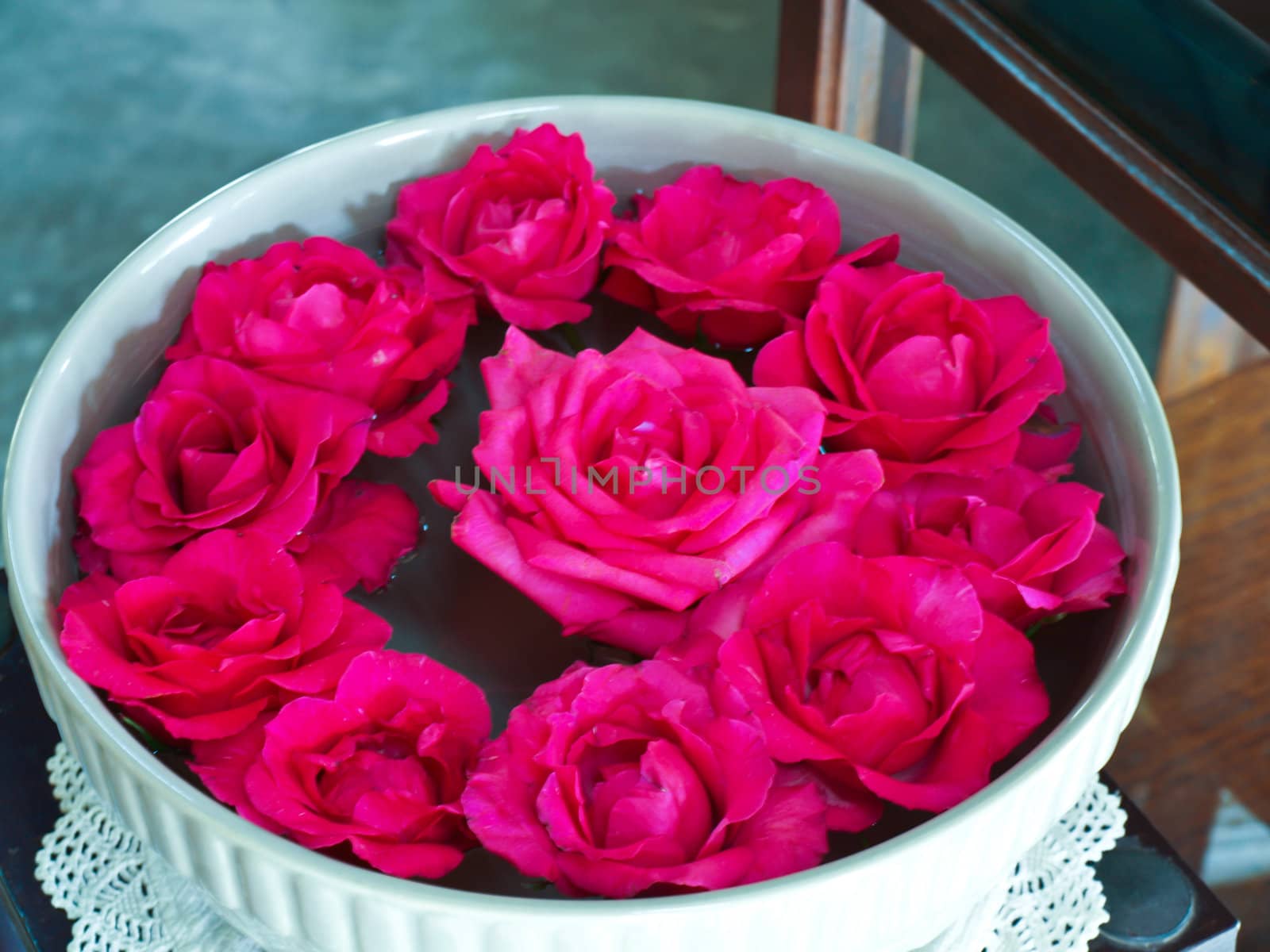Pink Chulalongkorn roses floating in ceramic bowl by gururugu