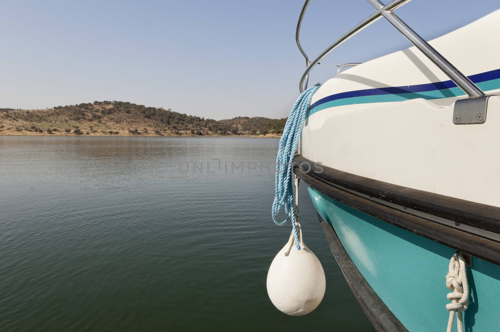 Detail of a blue and white boat prow with hanging fender