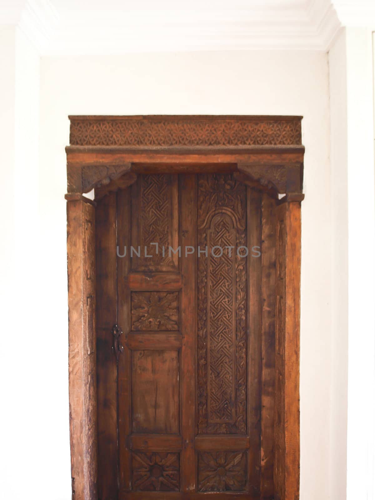 Antique Moroccan style wooden door on white wall