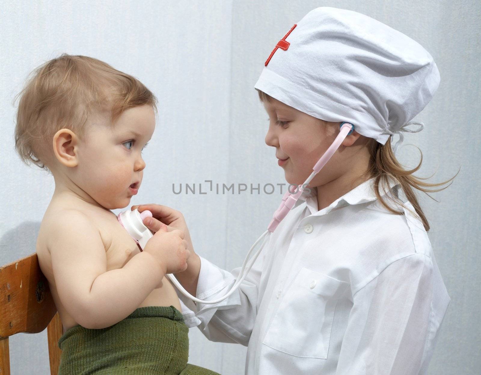 An image of girl and a baby playing a doctor